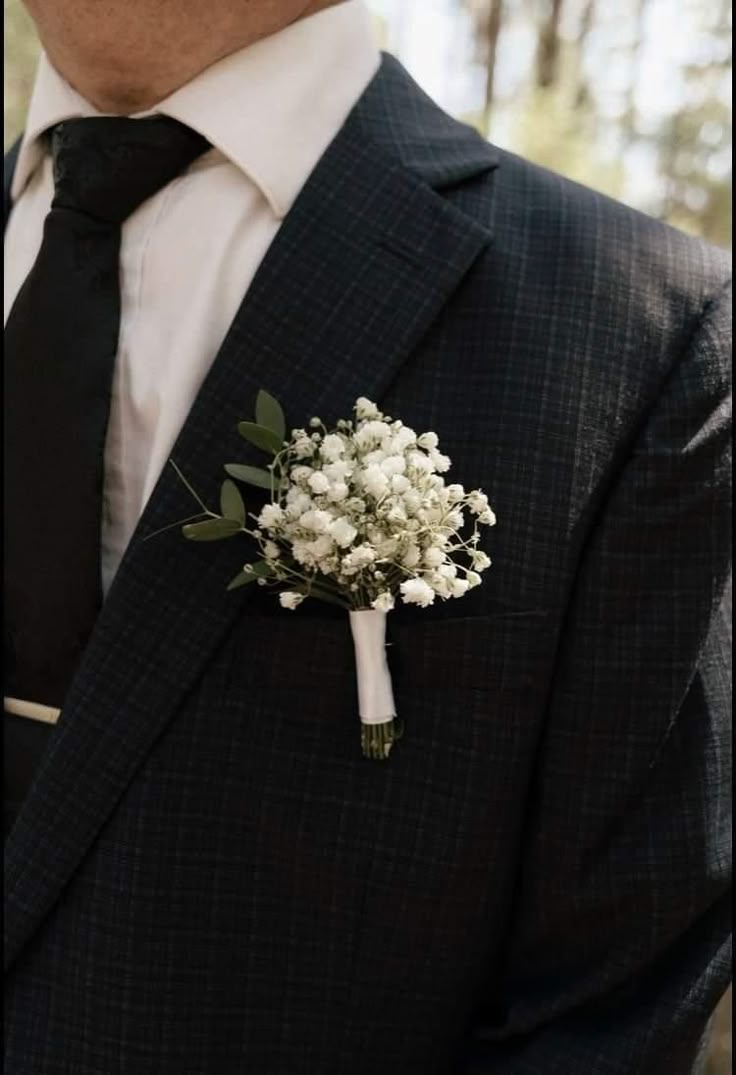 a man in a suit and tie with a boutonniere on his lapel