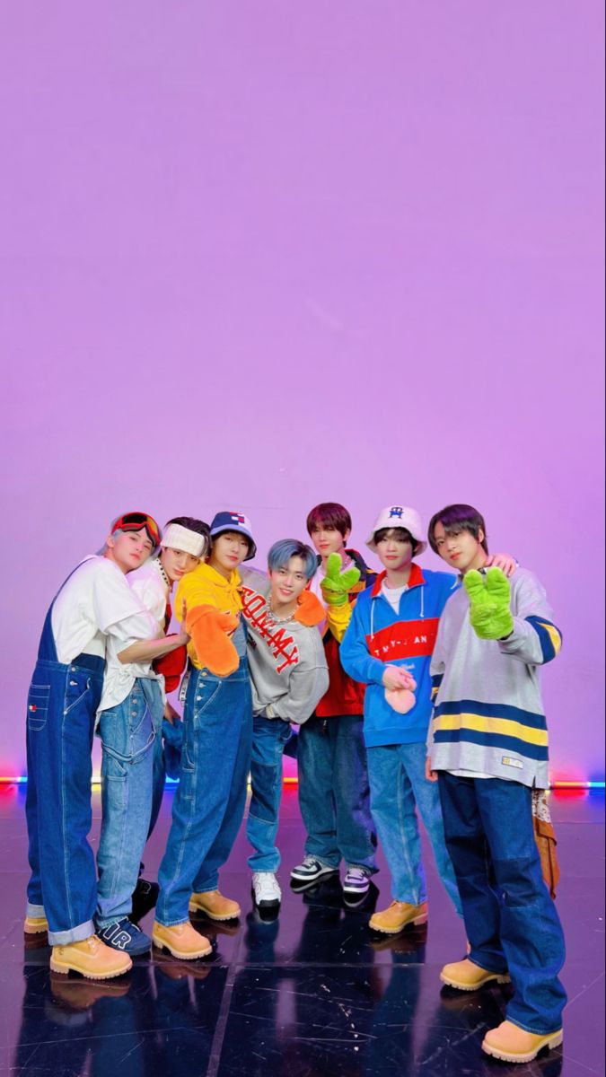 group of young boys standing in front of a purple wall