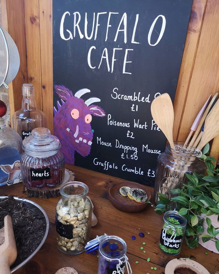 there is a sign that says gruffalo cafe next to other items on the table