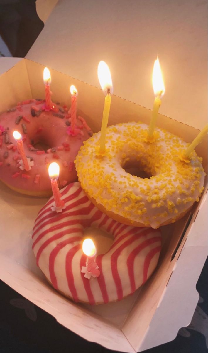 two donuts with candles are in a box