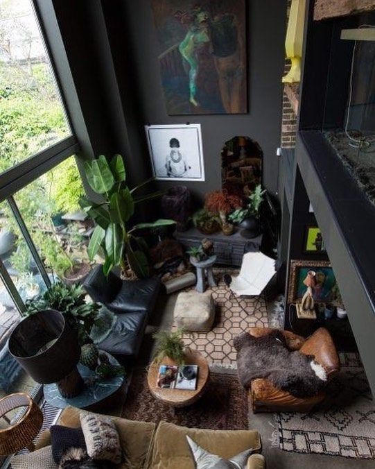 a living room filled with lots of furniture and plants