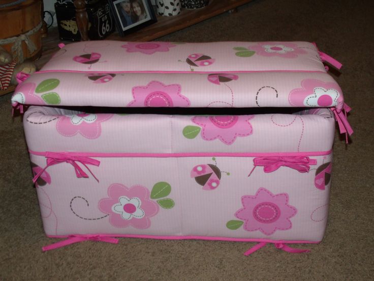 two pink storage boxes with flowers and ladybugs on them sitting on the floor