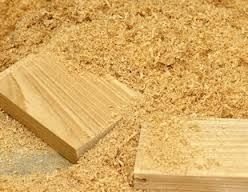 a piece of wood sitting on top of a pile of sand next to a wooden block