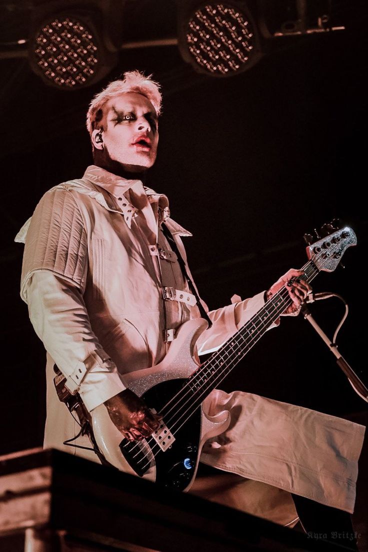 a man with blonde hair playing an electric guitar