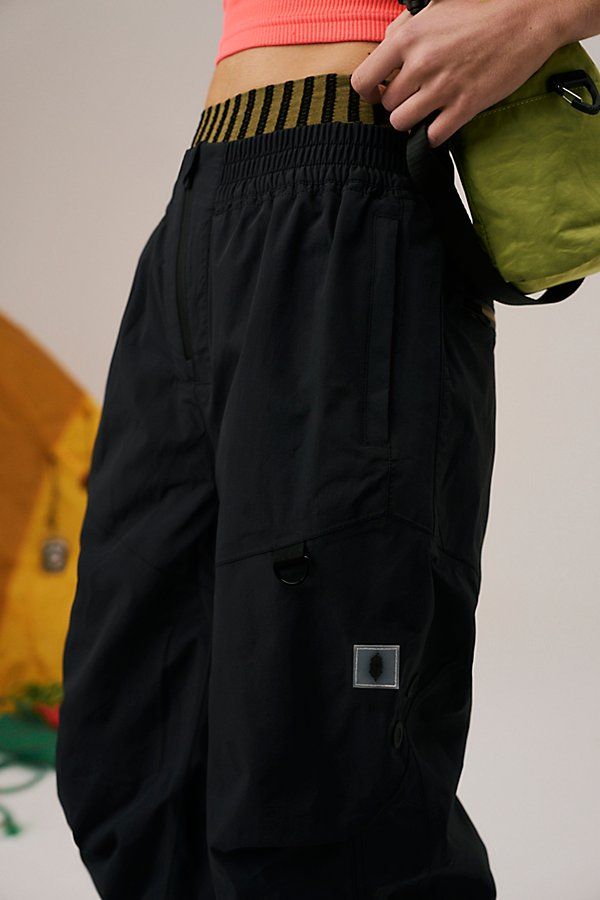 Suit up for wet weather in these packable rain pants, featuring a durable, waterproof nylon fabrication and roomy relaxed fit perfect for layering. **Fit:** Relaxed, high-waisted **Features:** 100% Nylon fabrication; durable; waterproof; fully mesh-lined; elasticated waistband; zipper opening; elasticated cuffs are Velcro adjustable; zippered hand pockets; zipper at lower leg for adjustability; snap openings at back for ventilation **Why We | Singin In The Rain Packable Pants by FP Movement at F Functional Wide Leg Parachute Pants For Outdoor, Functional Wide-leg Parachute Pants For Outdoor, Baggy Parachute Pants With Functional Pockets For Outdoor, Winter Utility Nylon Parachute Pants, Outdoor Nylon Wide Leg Pants, Outdoor Wide Leg Nylon Pants, Urban Nylon Parachute Pants For Outdoor, Nylon Wide-leg Parachute Pants For Outdoor Activities, Functional Wide Leg Nylon Parachute Pants