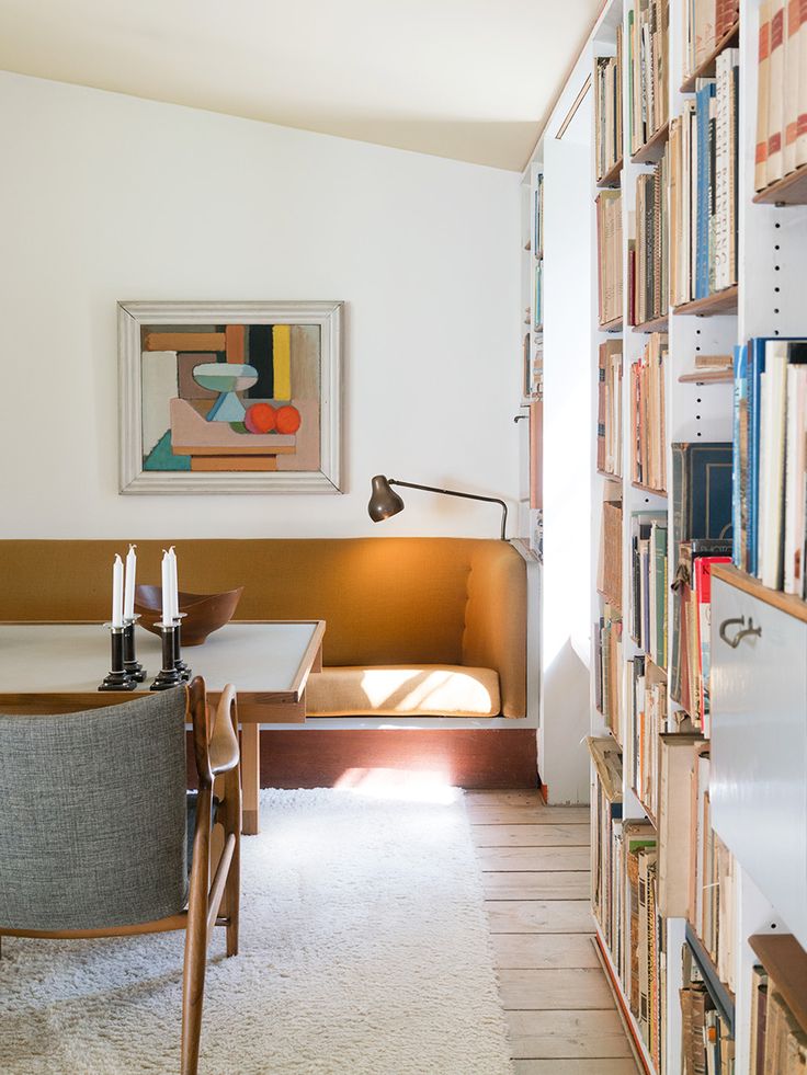 a living room filled with furniture and bookshelves next to a dining room table