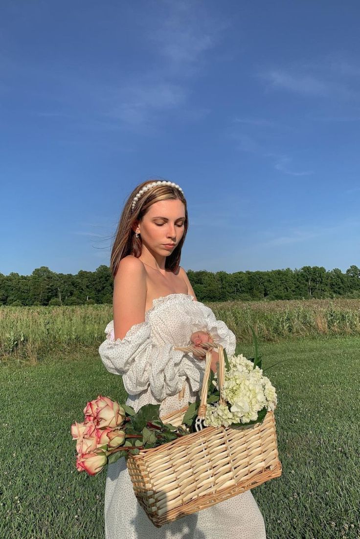 a beautiful young woman holding a basket full of flowers