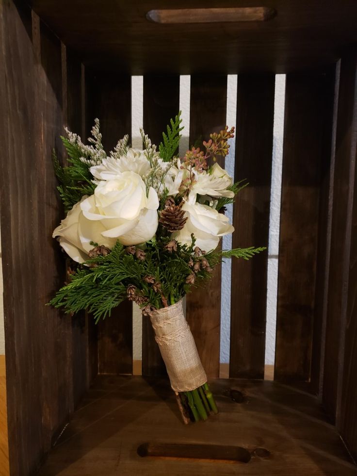 a bouquet of white flowers sitting on top of a wooden crate