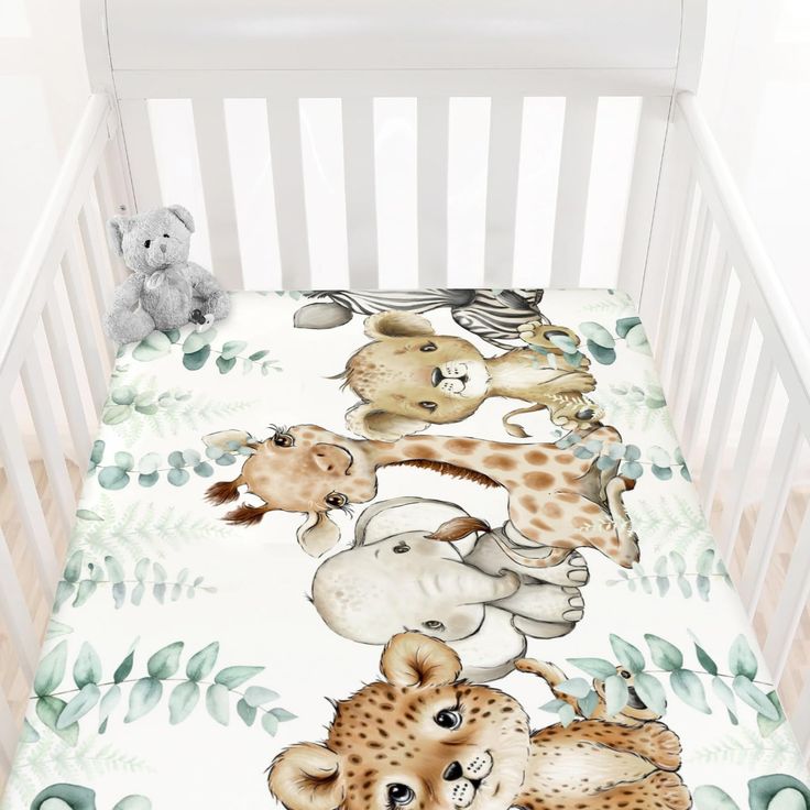 a baby crib with a blanket that has animals on it