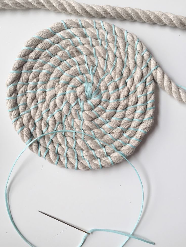 the rope is being used to make a round object with blue and white stripes on it