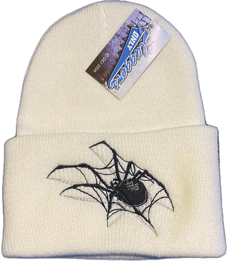 a white beanie with a black spider on it