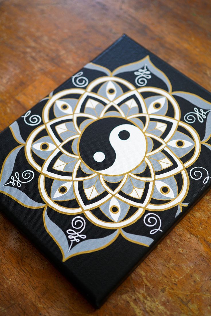 a black and gold art piece with a white yin sign on it's center