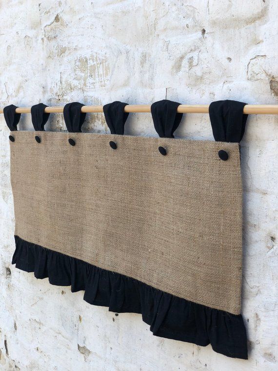 a burlock curtain with black ruffles hangs on a wall