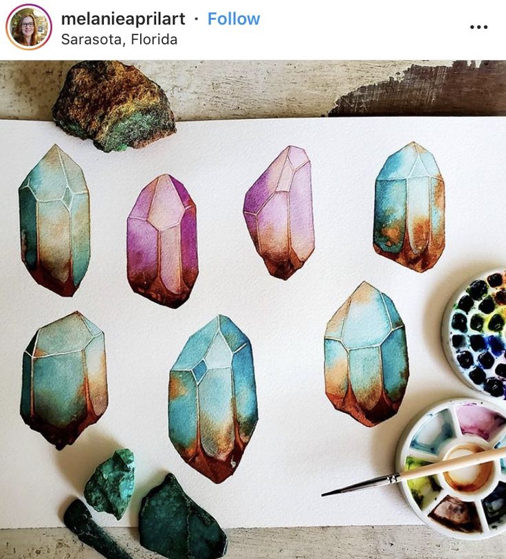 some colorful rocks and paint on a white paper with watercolors next to it