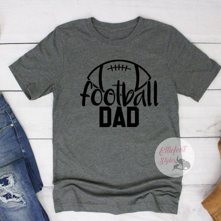 Proud Football Dad. The perfect dad shirt to wear for game day, practice, or out and about! Show your player who their biggest fan is. Express your style with our range of cool printed t-shirts and graphic tees. Casual Sports T-shirt For Father's Day, Game Day T-shirt With Screen Print For Sports Season, Father's Day Sports Fan T-shirt With Letter Print, Father's Day Team Spirit T-shirt With Crew Neck, Cotton Tops For Father's Day Sports Events, Cotton Tops For Sports Events On Father's Day, Father's Day Team Spirit Crew Neck T-shirt, Sports T-shirt With Text Print For Father's Day, Fan Apparel T-shirt For Game Day On Father's Day