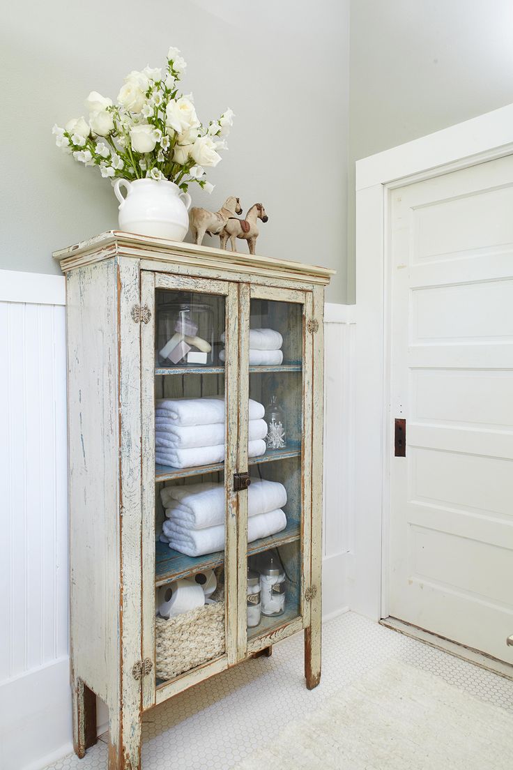 a white cabinet with towels and flowers on top