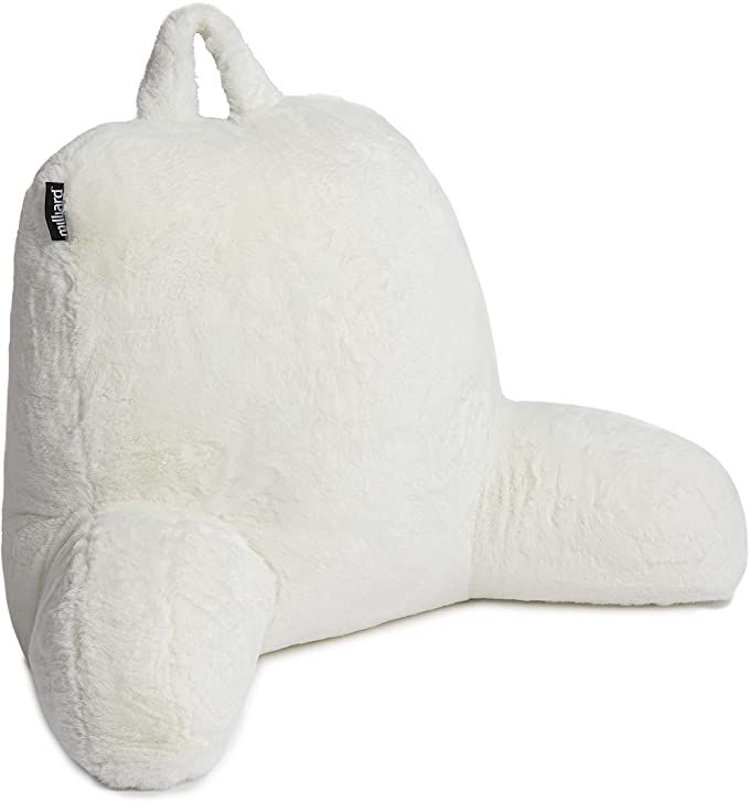 a large white stuffed animal laying on top of a white floor pillow with its eyes closed