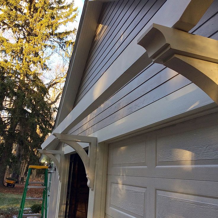 the side of a house that has a white siding and wood trimming on it