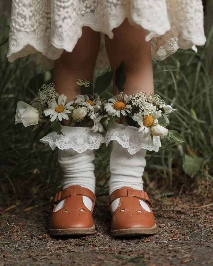 a close up of a child's feet wearing sandals with flowers on the toes