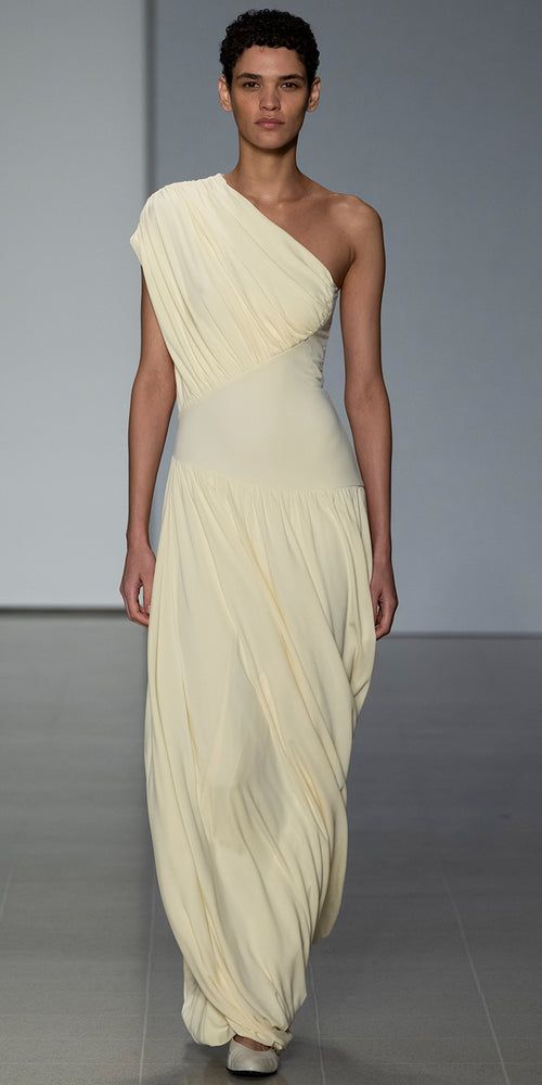 The Ugbad Dress with its one shoulder design and thoughtfully placed asymmetric basque is crafted in sustainable Italian crepe viscose jersey with beautiful weight and drape. Fully lined, the hemline features our signature twisted “bubble” design and finishes at the ankle.  In a soft buttermilk hue, this is a standout Draped Jersey Dress, One Shoulder Dress Outfit, All White Outfit Casual, Archive Dress, Draped Fashion, Drape Dresses, Yellow Dress Outfit, Dresses Runway, Draping Dress