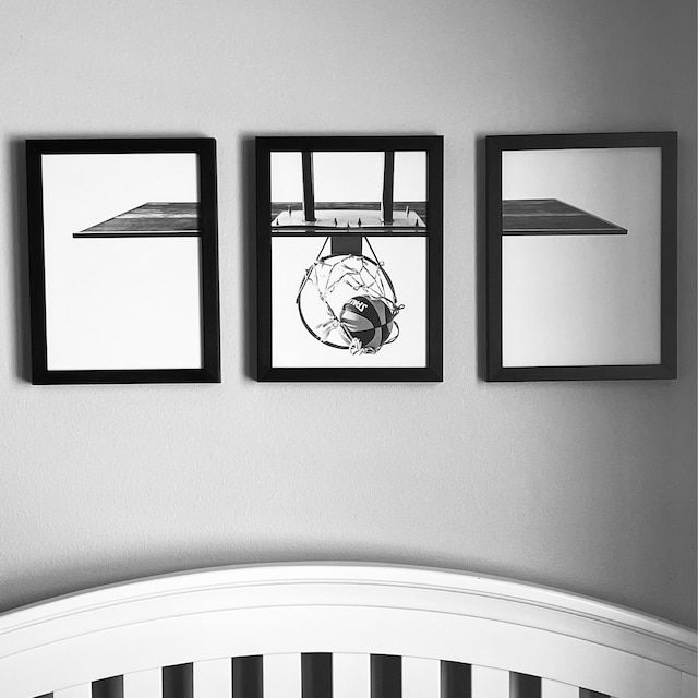 three black and white pictures hang on the wall above a crib