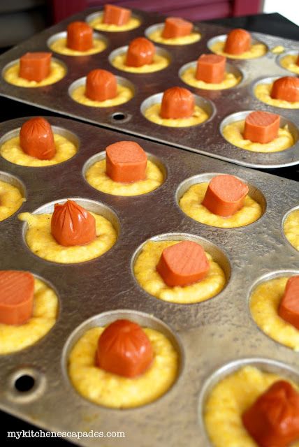 some cupcakes with orange icing in them sitting on top of pans