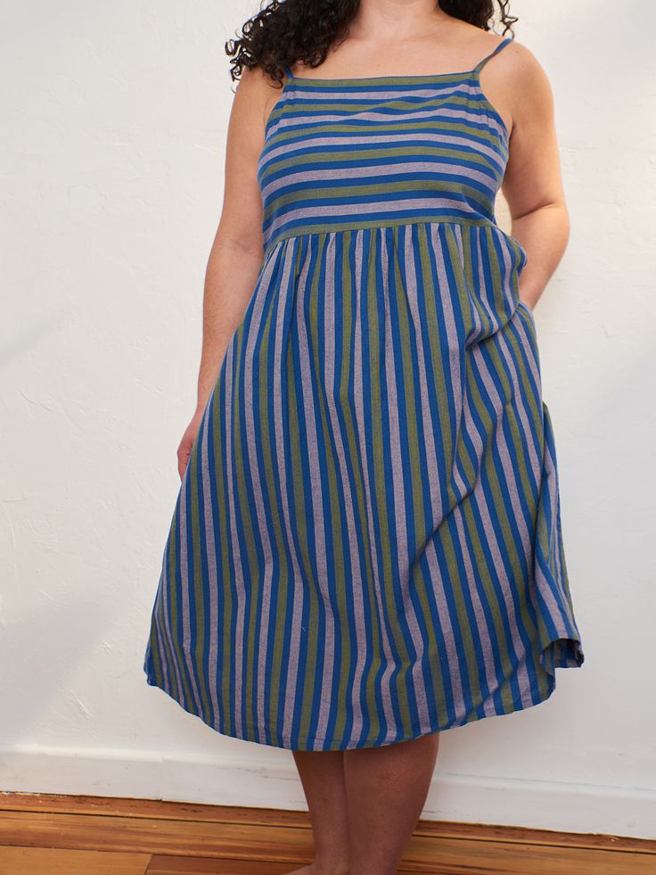 Every closet needs a strappy summer dress - its custom woven cotton in a pretty lavender stripe is an added bonus! Dress this up for an event like a graduation or shower, or throw it on to run errands. You'll feel comfortable and cool either way! Fit Note: Runs large in bust. Those between sizes will want to size down 100% Cotton Keyhole button at back Hidden pockets Empire waist Adjustable straps Length of size S is 38" from top of bodice Made fair trade in Nepal by one of our longstanding prod Striped Cotton Dress For Garden Party, Purple Sundress For Garden Party, Cotton Summer Dress With Vertical Stripes, Striped Cotton Sundress For The Beach, Lavender Cotton Dress For Garden Party, Striped Cotton Summer Sundress, Summer Cotton Sundress In Purple, Purple Cotton Sundress For Summer, Summer Purple Cotton Sundress