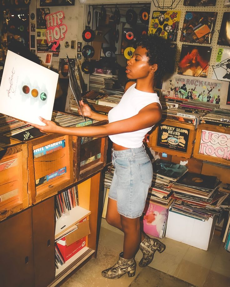 a woman standing in front of a record player