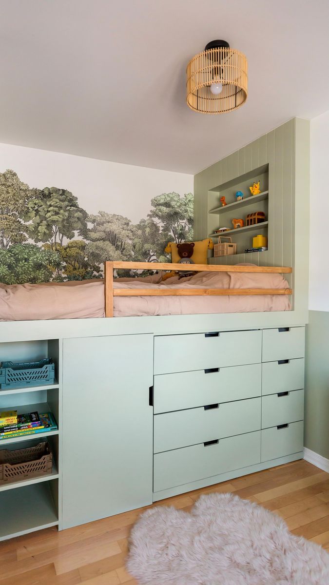 a room with a bed, dressers and shelves in front of a mural on the wall