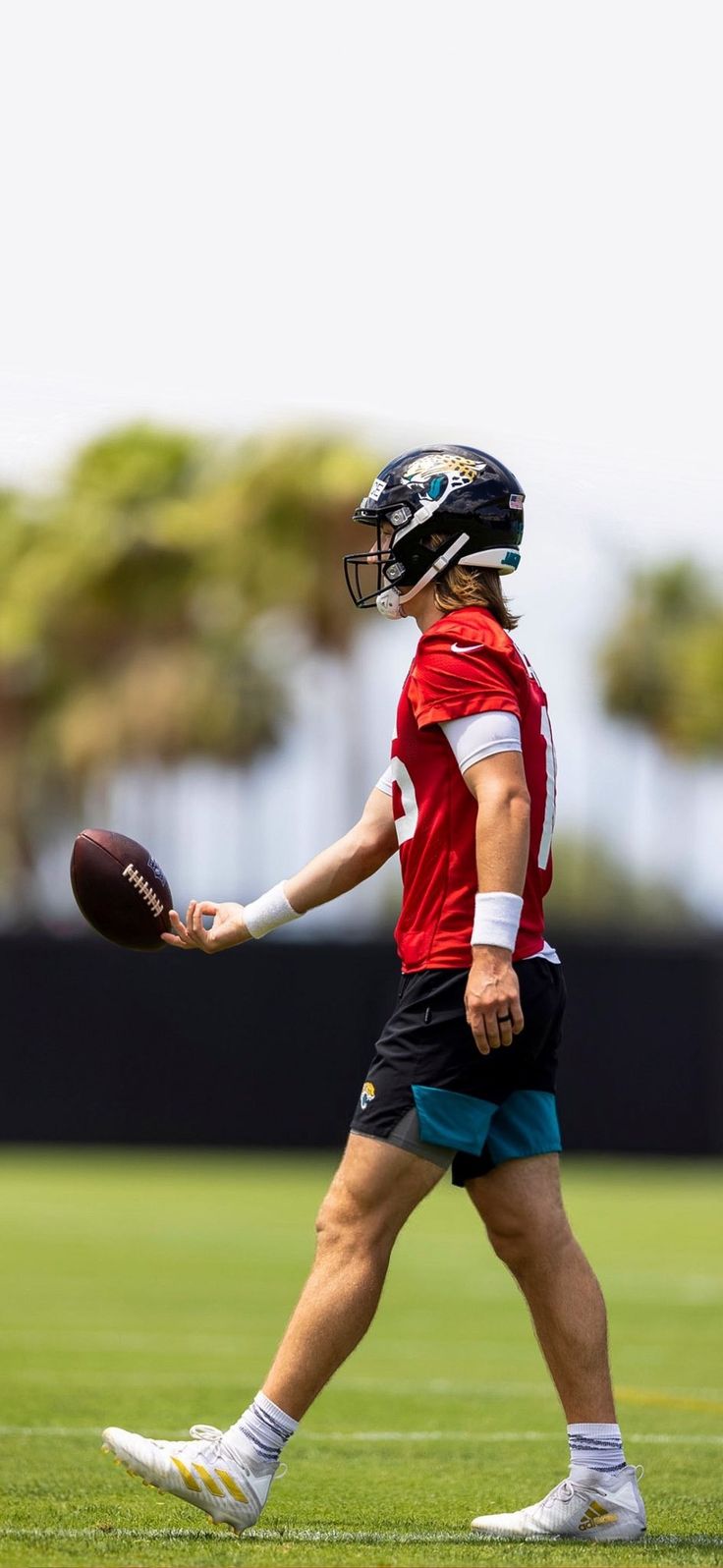 a man holding a football on top of a field