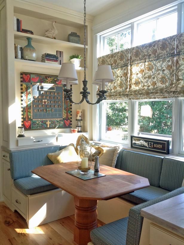 a kitchen table with two chairs and a bench in front of a window that is open to the outside