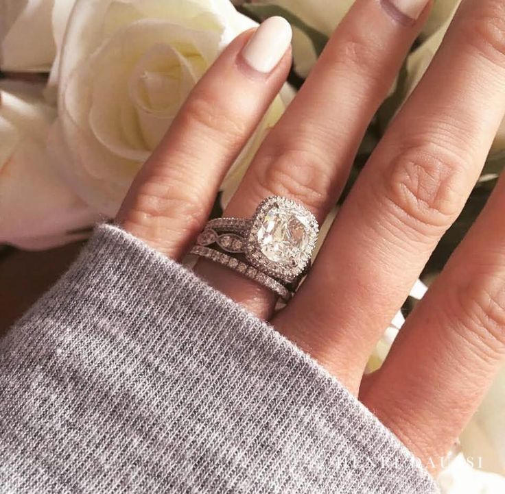 a woman's hand with two wedding rings on it