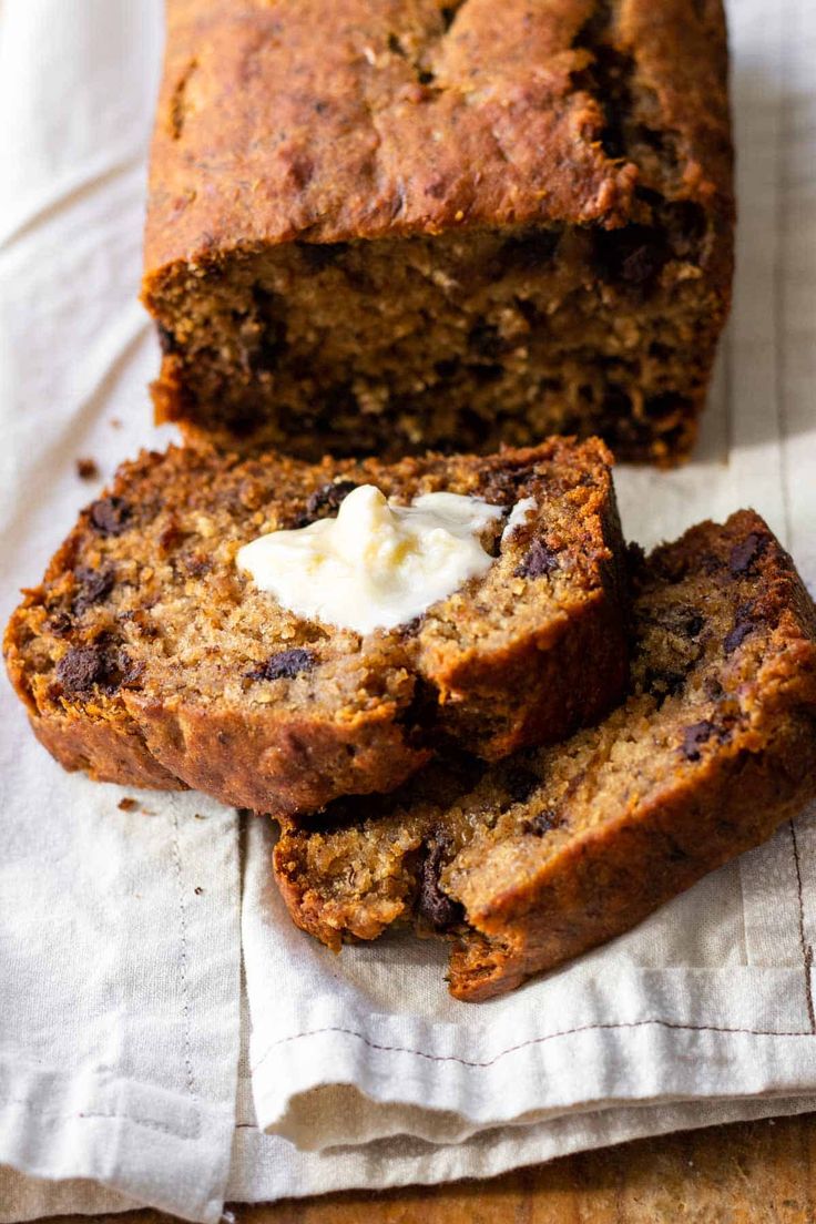 a loaf of banana bread with butter on top and two slices cut off from it