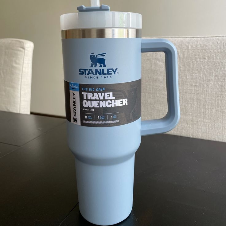 a blue travel mug sitting on top of a table