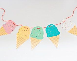 three ice cream cones are hanging from a string on a white background with polka dots