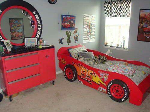 a child's bedroom decorated in red and black with cars on the bedspread