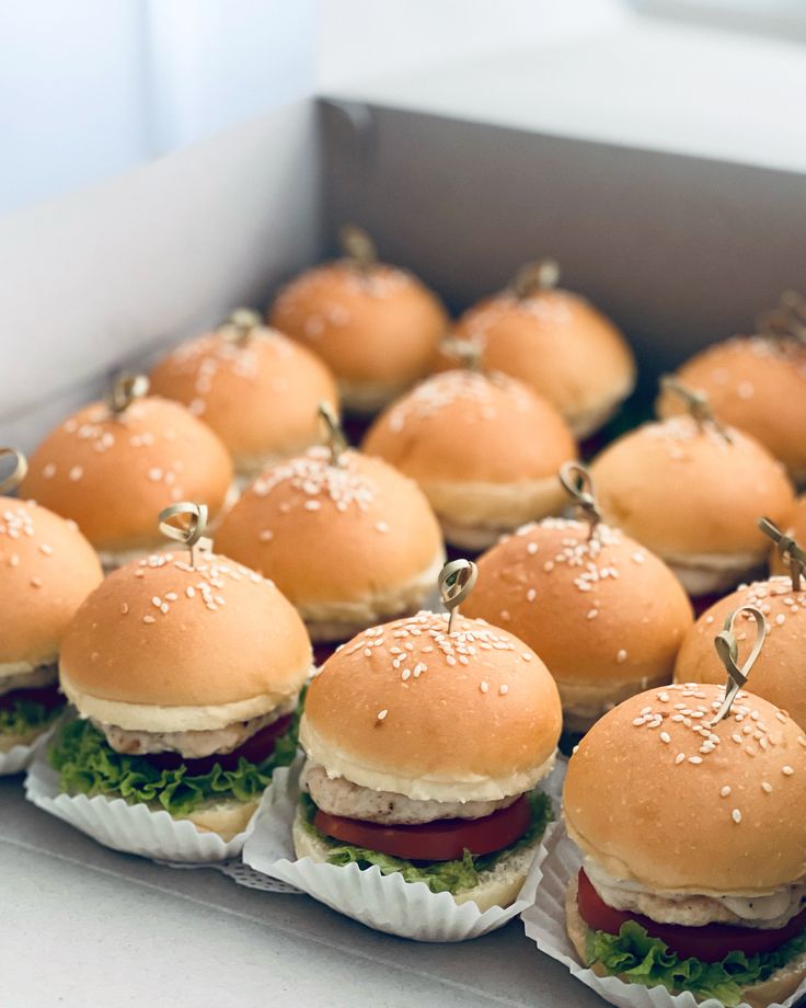 small hamburgers are lined up and ready to be eaten at a party or gathering