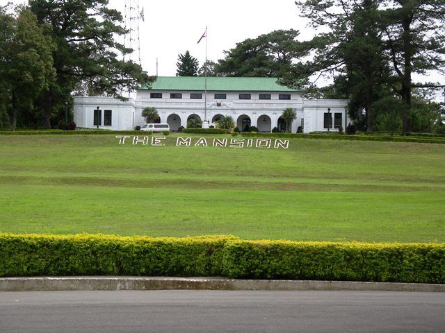 a large white building with the words time mansion written on it's front lawn