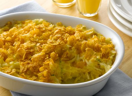 a casserole dish is shown on a table with orange juice in the background