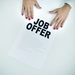 two hands holding a piece of paper with the word job offer written on it in black