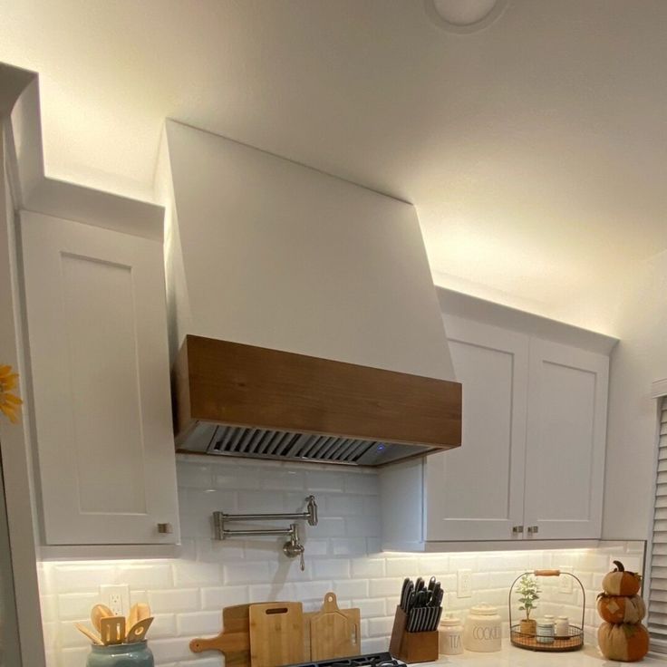 a stove top oven sitting inside of a kitchen next to white cabinets and counter tops