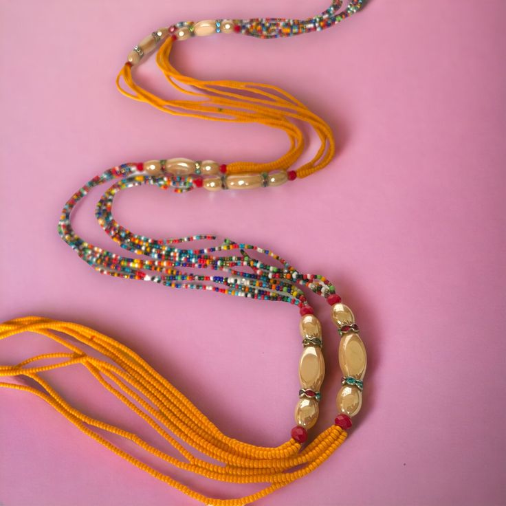 **DRIP FAIRY IS CURRENTLY OPEN FOR PRE-ORDERS ONLY! ALL ORDERS WILL NOT BE SHIPPED OUT UNTIL FEBRUARY 24, 2024. AS A THANK YOU TO THOSE PRE-ORDERING THESE ORDERS WILL ALSO INCLUDE A FREE GIFT! This handmade Ivorian waist bead has an incredibly beautiful four strand design in the colors of purple, gold, and red. Each waist bead is carefully crafted using a combination of strong threads woven together to create a durable and long-lasting piece. The beads themselves are made from glass and each one is carefully chosen to ensure a consistent look and feel to the waist bead. Crafted using high-quality materials, this waist bead is durable and designed to last. The strands provide a comfortable and secure fit, while the adjustable length ensures that it can fit a wide range of waist sizes. The p Bohemian Beaded Chain Beads For Festive Occasions, Bohemian Beaded Chain For Festive Occasions, Bohemian Multi-strand Small Beads, Traditional Beaded Necklaces With Colorful Beads For Festival, Festive Artisan Adjustable Beaded Necklaces, Traditional Festival Beaded Necklaces, Traditional Beaded Necklace For Festivals, Festive Bohemian Beaded Necklaces With Tiny Beads, Festive Bohemian Beaded Necklace With Tiny Beads