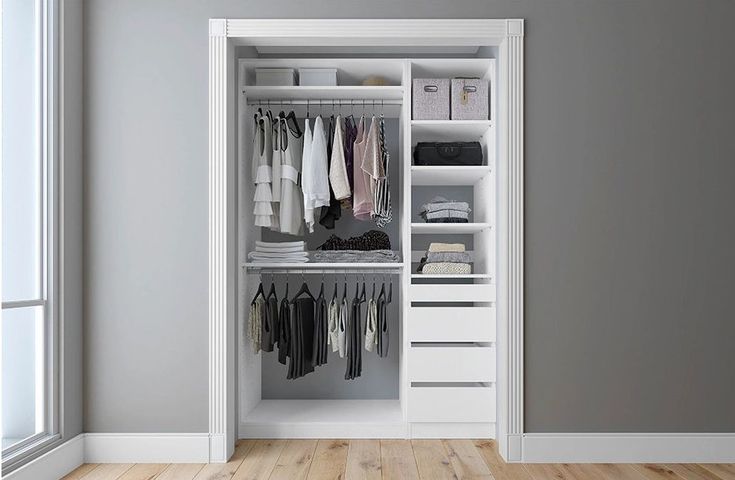 an open white closet with clothes hanging on the doors and shelves in front of it