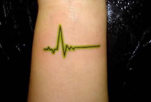 a green heartbeat tattoo on the wrist