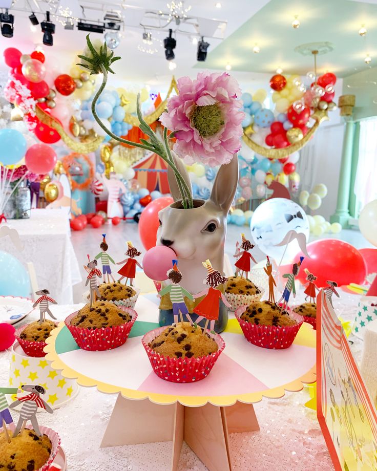 a table topped with cupcakes and muffins covered in frosting