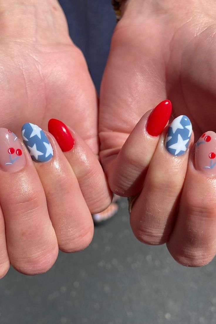 These almond-shaped nails are a tribute to the Fourth of July spirit. A glossy red polish shines brightly, complementing nails with a soft blue base featuring white stars. Accentuating the theme, another nail showcases an adorable pair of cherries against a transparent background, adding to the playful patriotic vibe. This manicure perfectly embodies the celebration of Independence Day. 🎆✨  // Photo Credit: Instagram @nailsby.syd Cherry Fourth Of July Nails, Chic 4th Of July Nails, 4th Of July Nails With Cherries, Fourth Of July Nails Cherry, Cherry 4th Of July Nails, 4th Of July Cherry Nails, 4th Of July Aura Nails, Red White Blue Nails Fourth Of July, Red Fourth Of July Nails