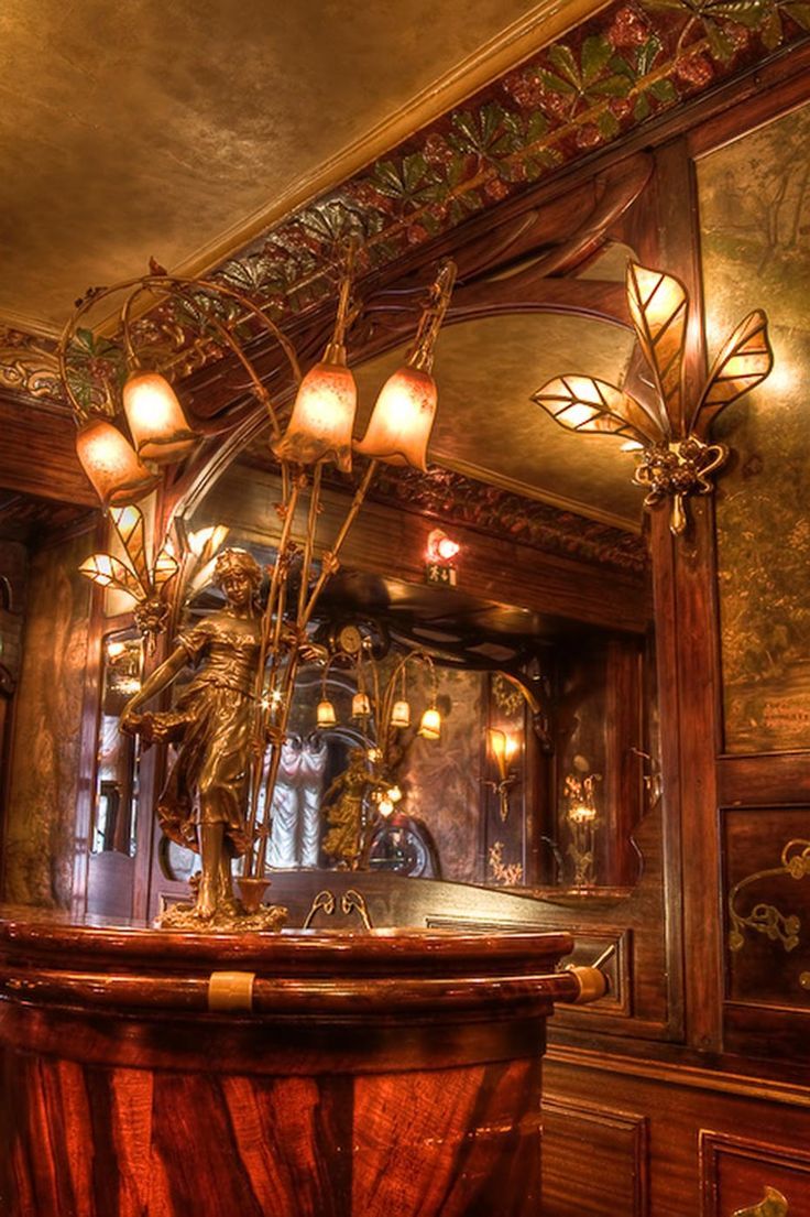 an ornately decorated bar with lights on the ceiling and mirror in the back ground