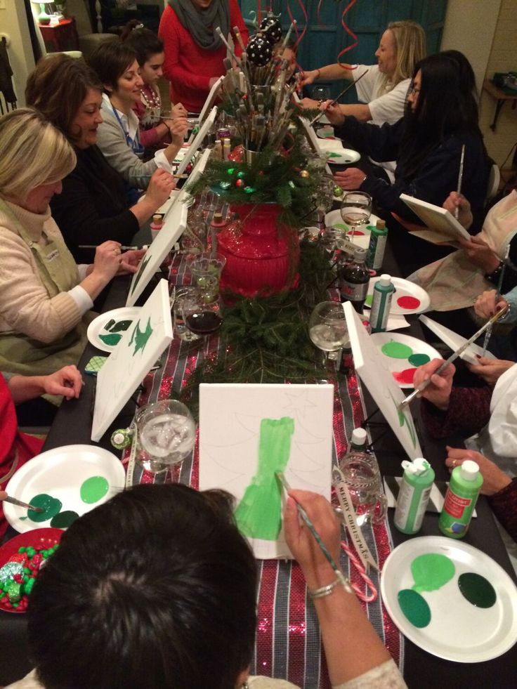 a group of people sitting around a long table with plates and napkins on it