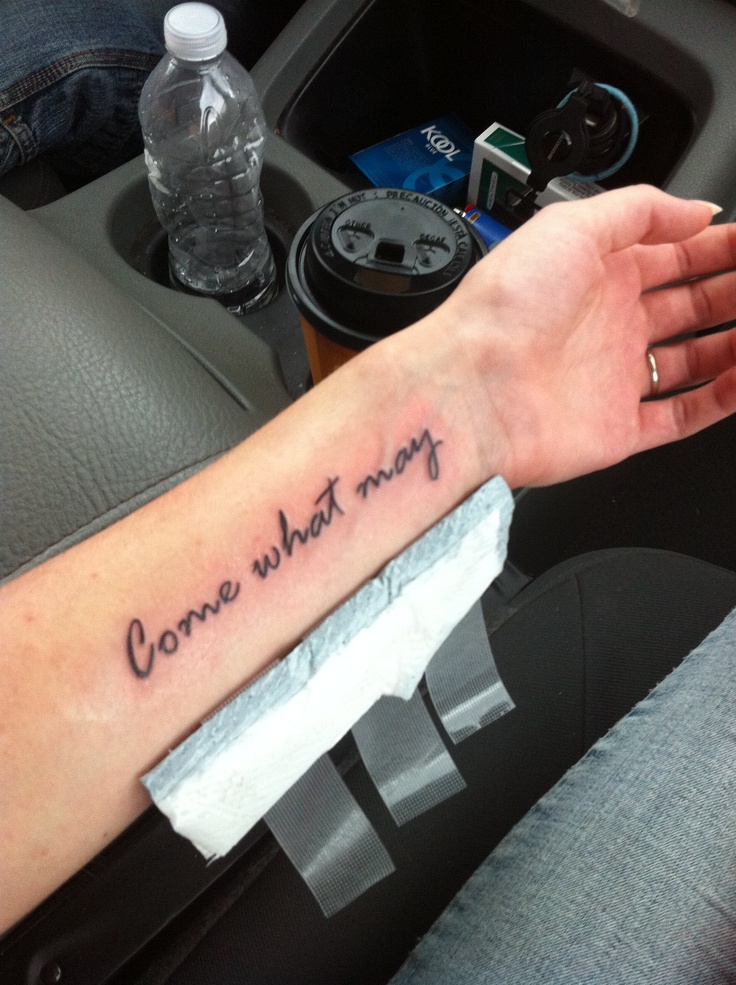 someone is holding their arm with the words come what may written on it in black ink