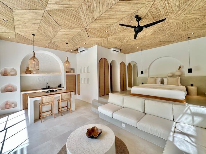 a bedroom with white furniture and wooden ceiling